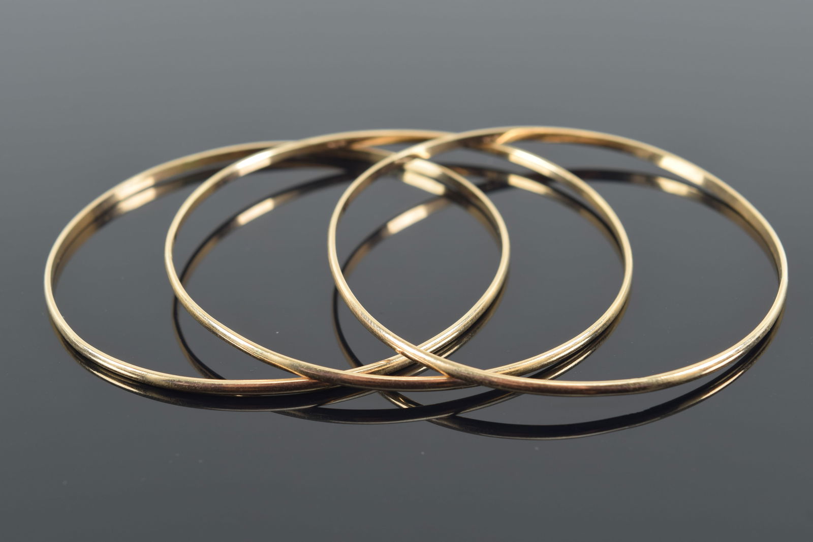3 14K gold bangle bracelets. Marked 14K. Each about 2.25in diameter. Very slightly out of round. (1 of 3)