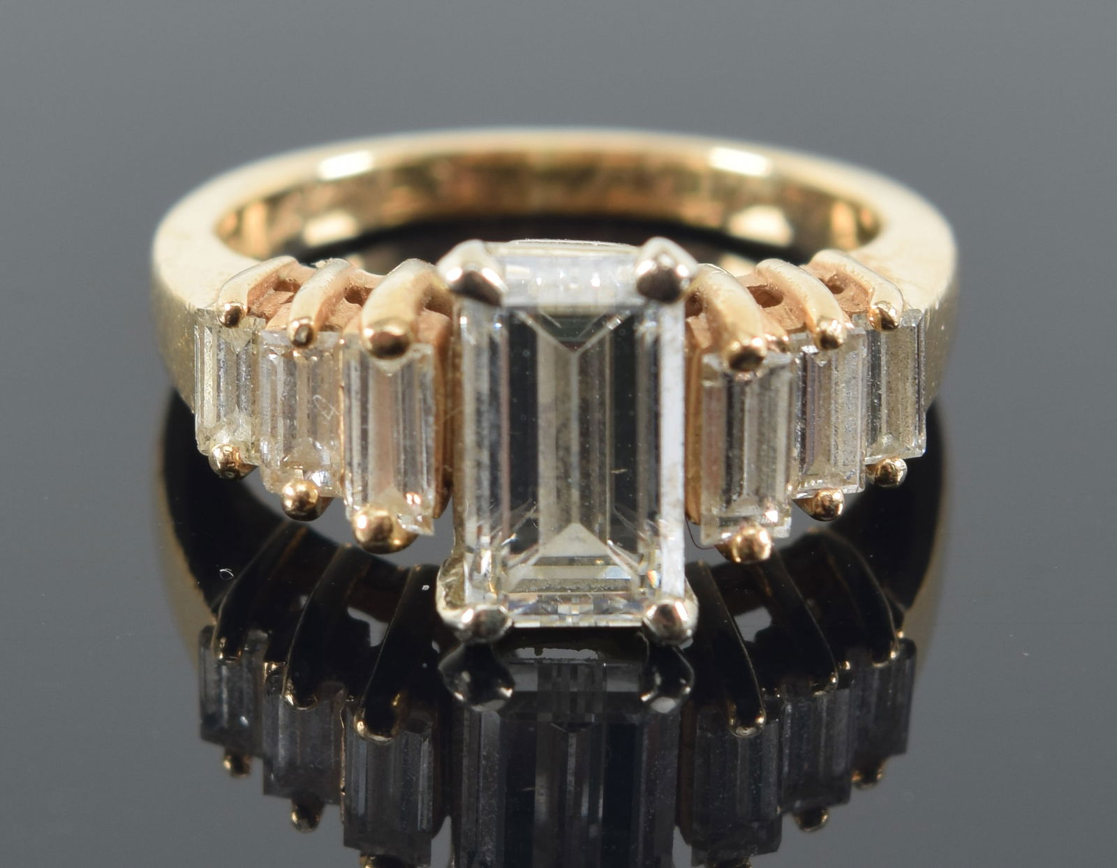 14K gold diamond mounted ring. Center emerald cut diamond approx. 1ct. 7.7 x 4.3mm. Flanked by 3 (1 of 7)