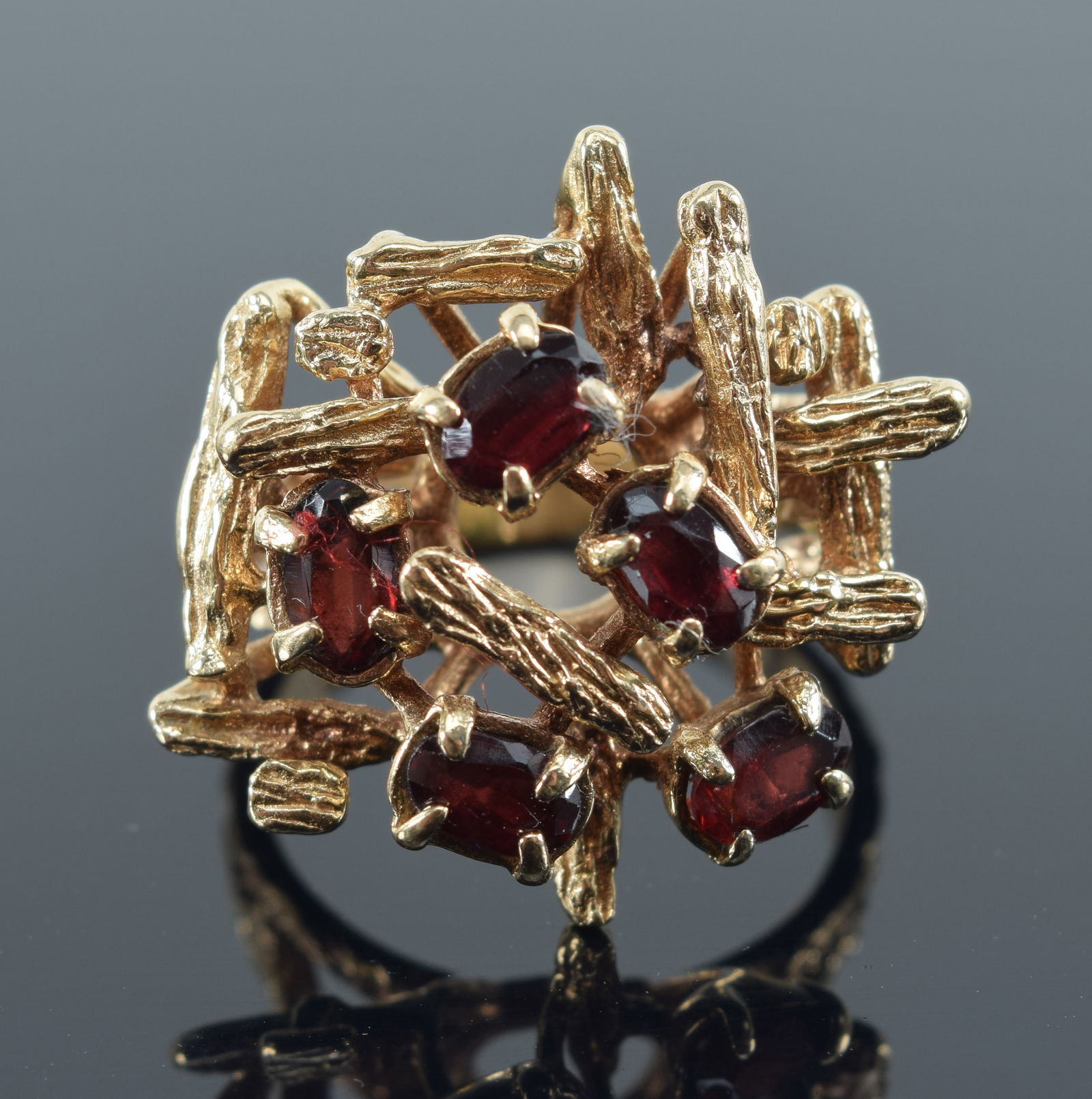 10K gold garnet ring. Brutalist form setting with 5 oval garnets. Stamped 10K. Ring size 7.25. 7.4: 10K gold garnet ring. Brutalist form setting with 5 oval garnets. Stamped 10K. Ring size 7.25. 7.4 grams.