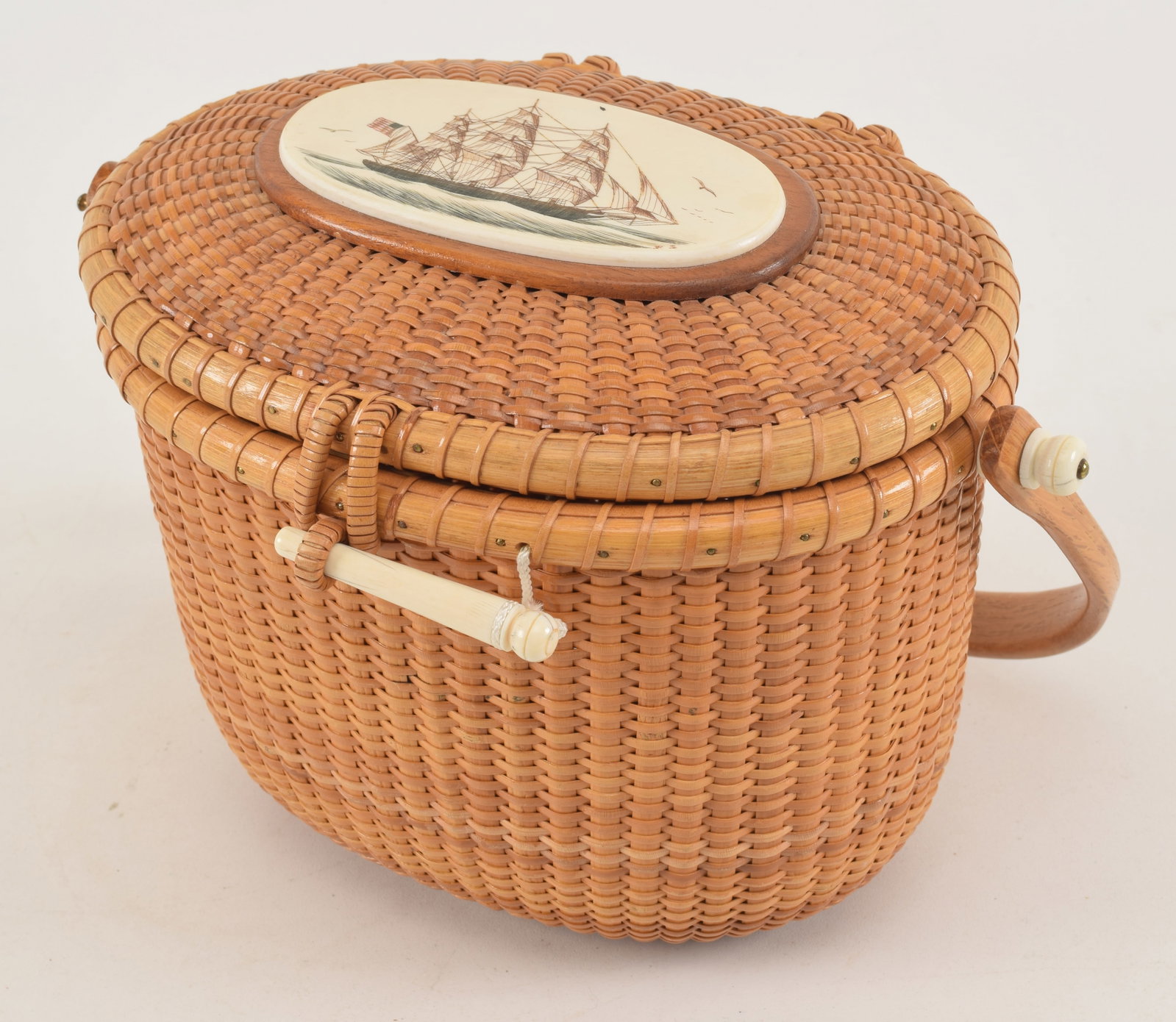 William and Judy Sayle Nantucket basket purse. Scrimshaw American clipper ship panel on top. Plaque: William and Judy Sayle Nantucket basket purse. Scrimshaw American clipper ship panel on top. Plaque with name of owner on interior of lid, Georgia Mittelman. Signed W + J Sayle 1978 on underside. Hard
