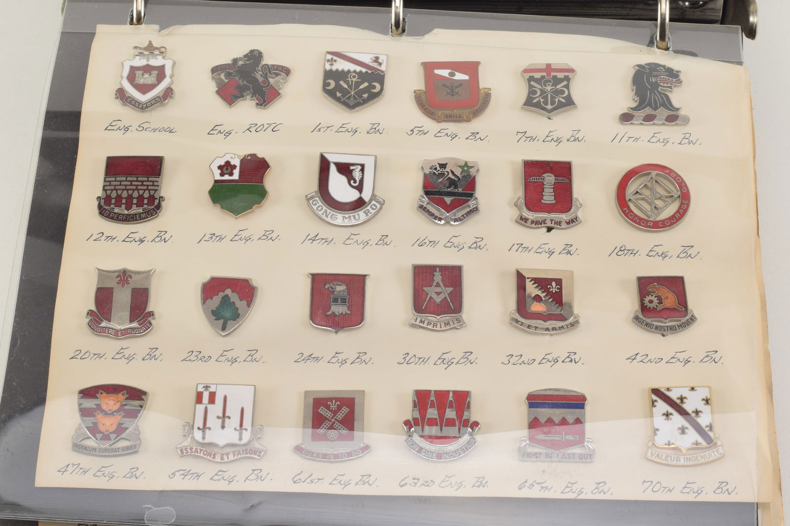 Collection of enameled US military pins. Includes 3 pages of Engineer Battalion pins, and an (1 of 7)