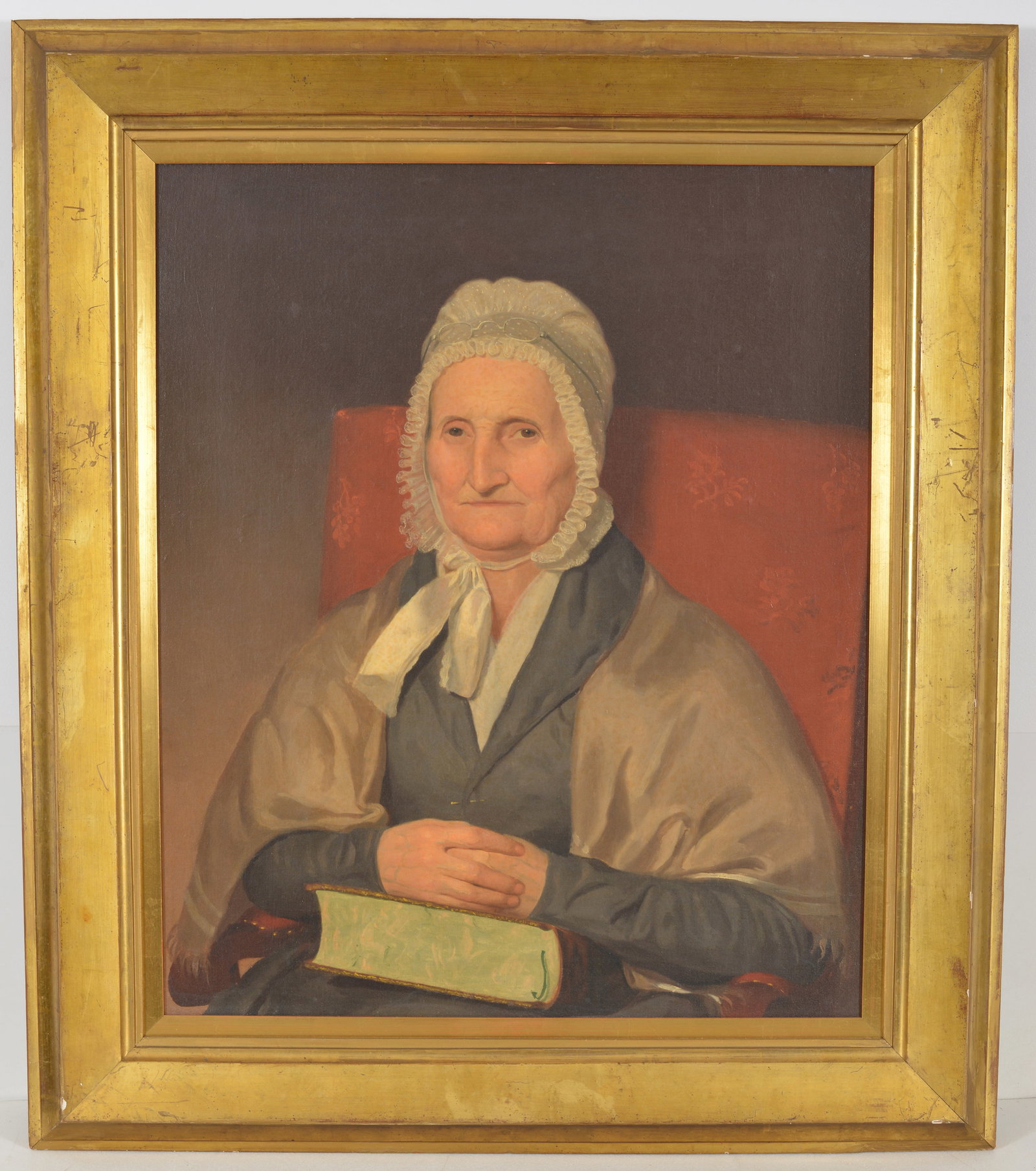 19th century American folk art portrait of a woman seated in a red chair holding a book and wearing (1 of 8)
