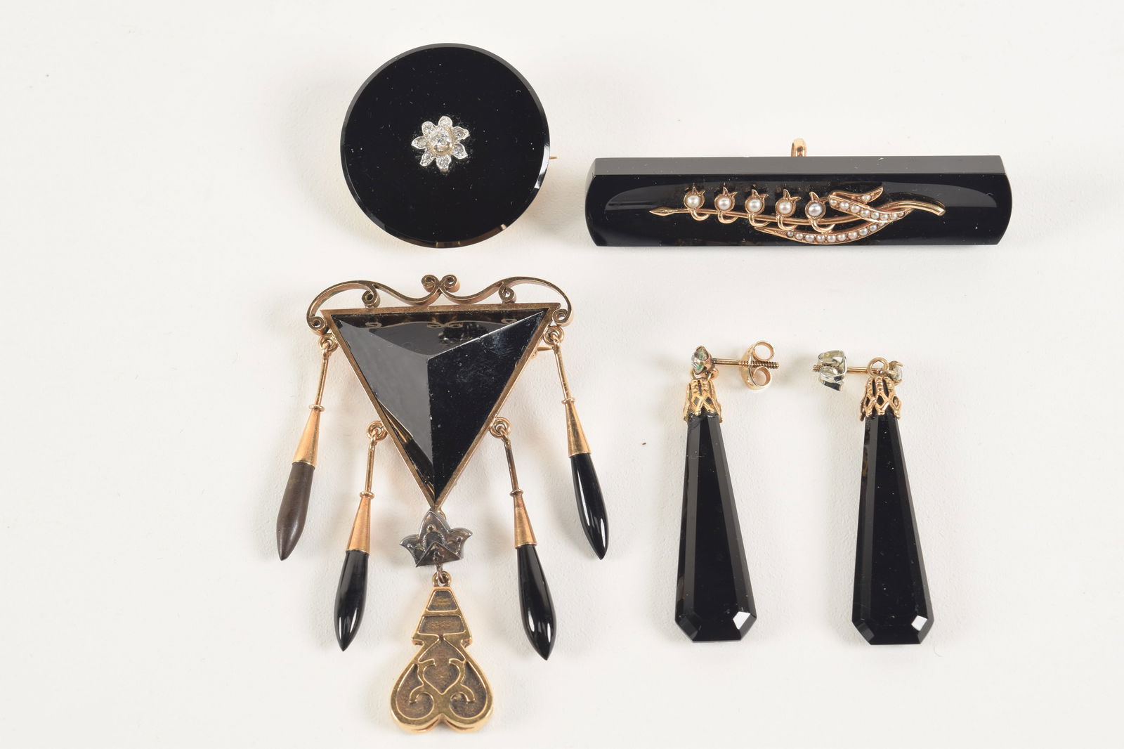 Lot of gold mounted Victorian black onyx jewelry. 1) 18K round pin with diamond star design. Tests (1 of 6)