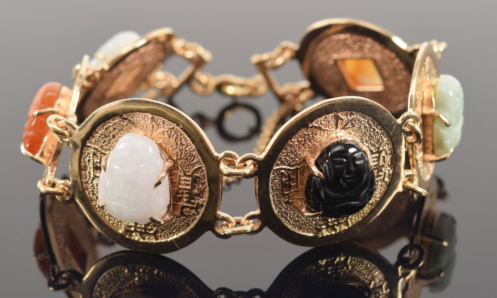 14K gold heavy coin design bracelet. 6 coin medallions mounted with carved stone heads. Marked 14K (1 of 4)