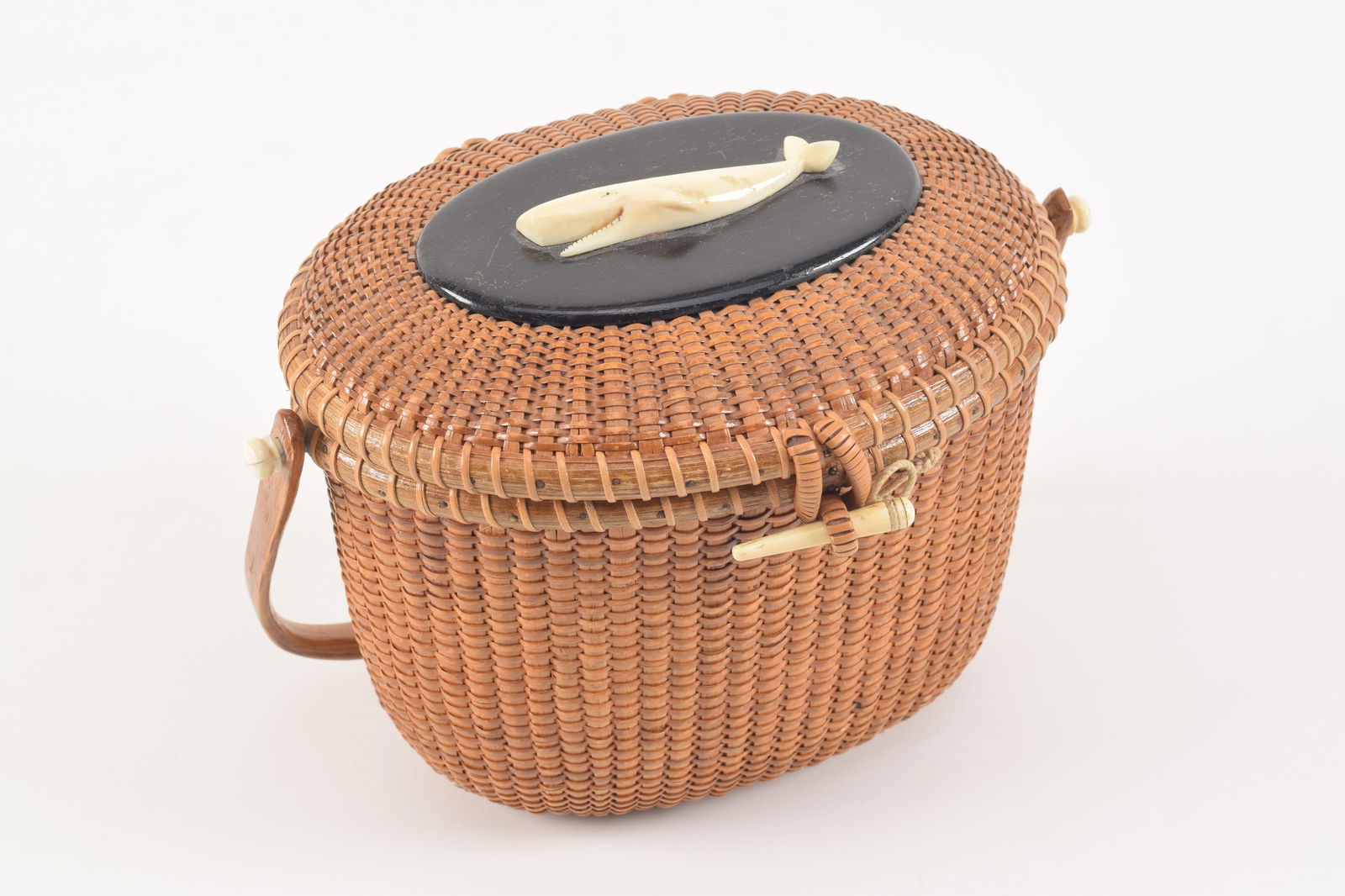 Jose Formoso Reyes Nantucket basket purse. Scrimshawed whale set on dark wood panel on lid. "Judith: Jose Formoso Reyes Nantucket basket purse. Scrimshawed whale set on dark wood panel on lid. "Judith Banks" inscribed panel on inside lid. Signed and inscribed Made in Nantucket by Reyes on the bottom.