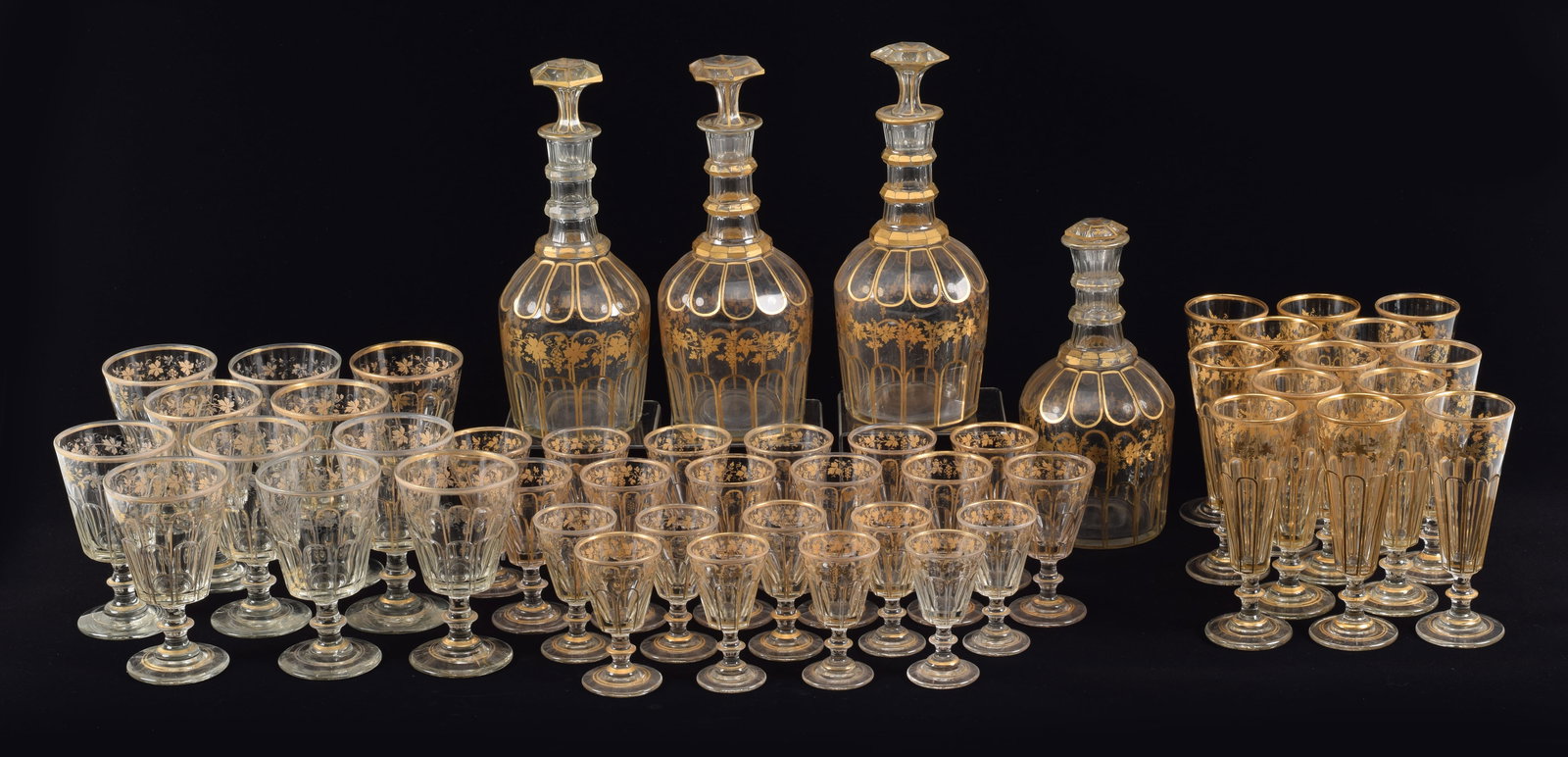 Large set of gilt decorated cut glass decanters and stemware. To include: 13 champagnes (7in high), (1 of 9)