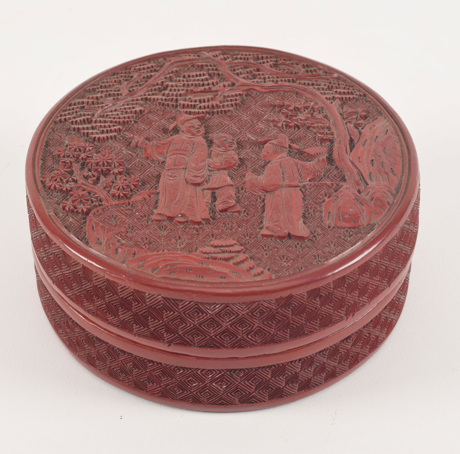 Cinnabar box. China. 19th century. Round form. Surface carved with a gathering of scholars. 4in (1 of 7)