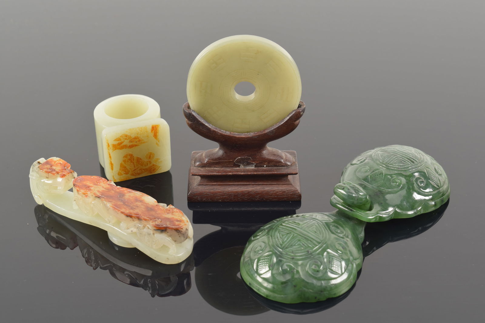 Lot of 4 jade carvings. China. 19th/20th century. To include: a archer's ring, garment hook, 2 part (1 of 6)