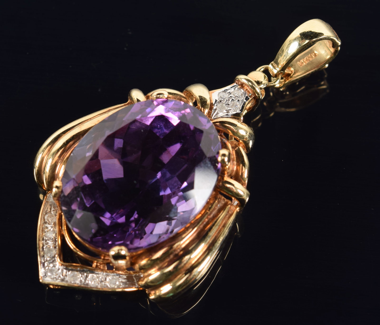 14K gold diamond and large amethyst colored spinel pendant. Oval faceted central stone measuring: 14K gold diamond and large amethyst colored spinel pendant. Oval faceted central stone measuring approx. 18 x 22mm. Small round diamonds set in white gold above and below. Stamped 14K 585 and star hal