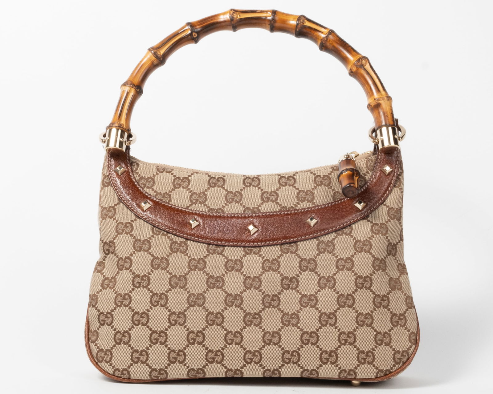 Gucci monogrammed canvas bamboo handled purse. Leather studded trim. One interior zippered pocket. (1 of 6)