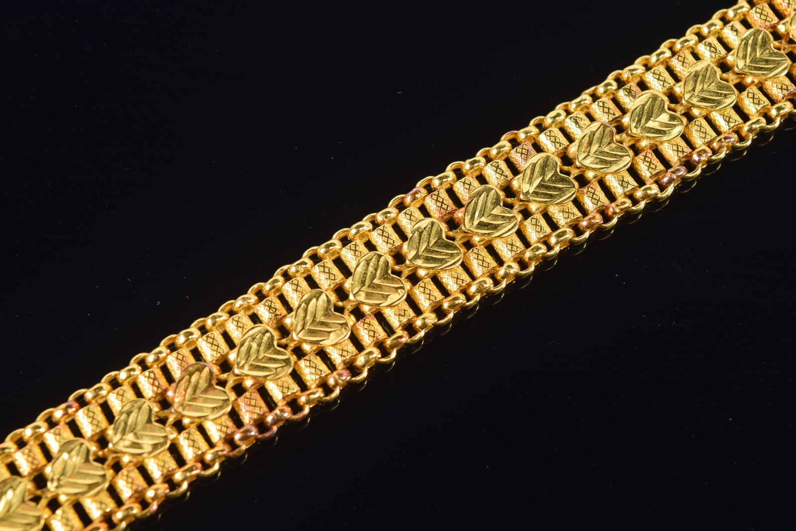 18K gold heart and cylinder chain bracelet. Single row of hearts between a cylinder and chain link.: 18K gold heart and cylinder chain bracelet. Single row of hearts between a cylinder and chain link. Unmarked (possible touch mark on clasp). Tests as 18K. 7in length. 30.4 grams.
