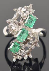 18K white gold emerald and diamond mounted ring. 3 central graduated emerald stones (largest 3.6 x