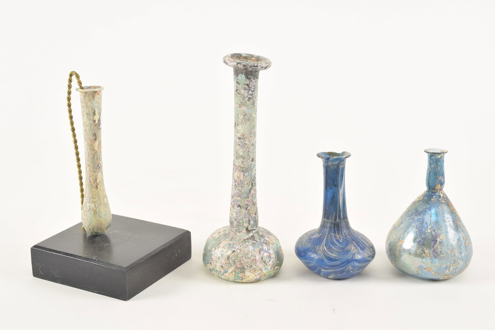 [4] Roman glass bottles. 1) Tall bottle with iridescent patina. 5.5in high. 2) Blue glass bottle (1 of 7)