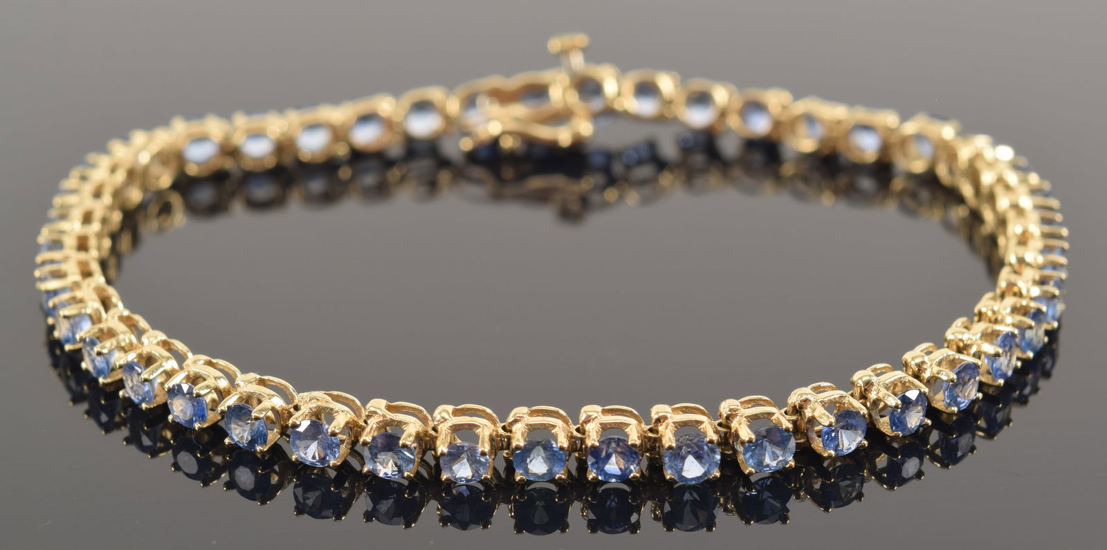14K gold sapphire mounted bracelet. Set with 43 round cut stones, each measuring approx. 3mm (1 of 7)