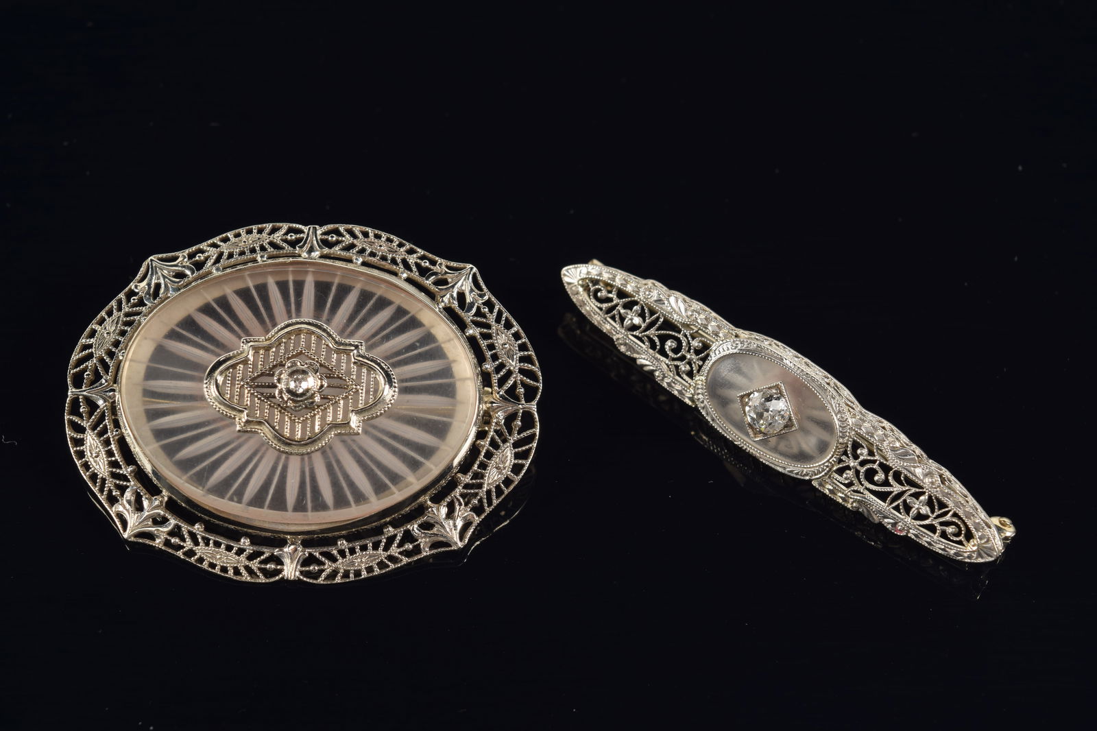 2 14K white gold diamond and carved crystal mounted pins. Larger pin with small round diamond (1 of 2)