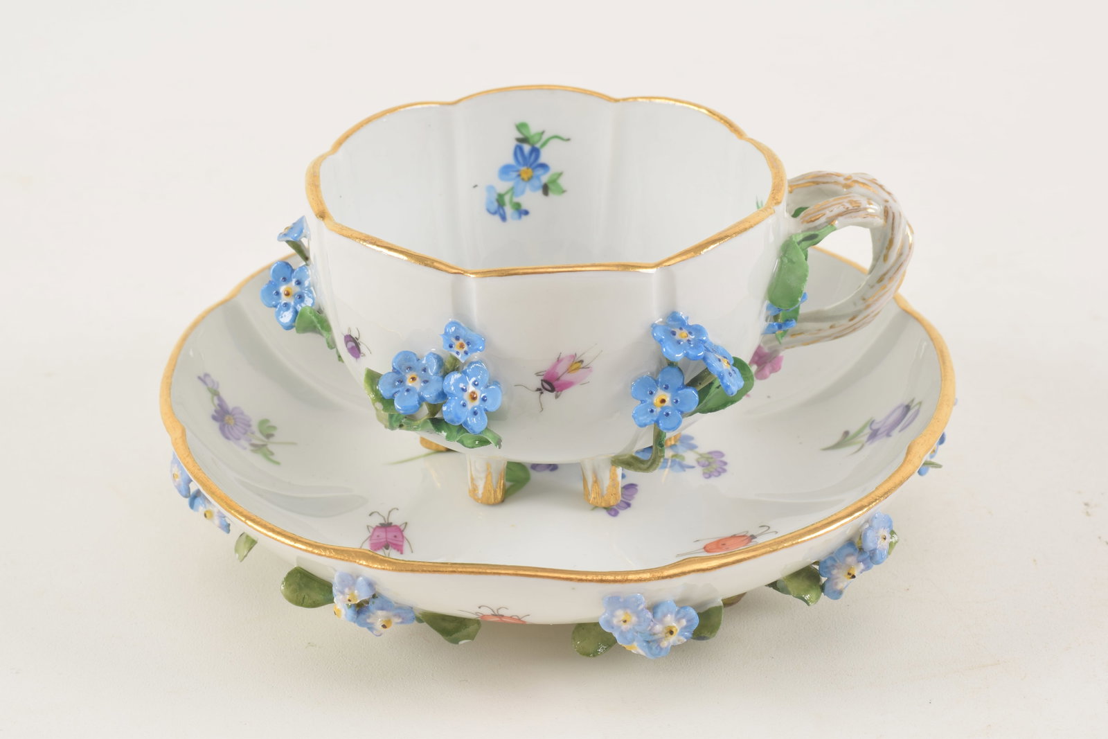 18th/19th century Meissen hand painted porcelain cup and saucer. Applied flora bouquets with hand: 18th/19th century Meissen hand painted porcelain cup and saucer. Applied flora bouquets with hand painted floral motifs and ladybugs. Underglaze blue cross swords mark on cup and saucer. Breaks to app