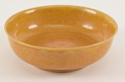 Porcelain bowl. China. 19th century or earlier. Mustard yellow glaze with incised dragons. 5.25in