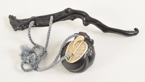 2 netsuke. Japan. 19th century. To include: a dragon shaped ebony sashi, together with a Hoi Tei's