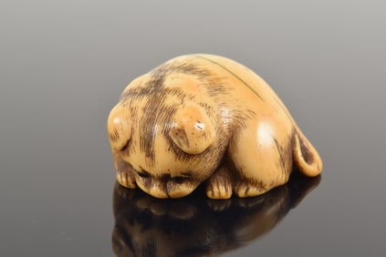 Netsuke. Japan. Ca. 1800. Osaka. Charming akita pup with inlaid eyes. 5 x 2cm.
