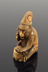Netsuke. Japan. 19th century. Monkey in the guise of a shinto priest holding a shakyo. 5.5 x 3.5cm.