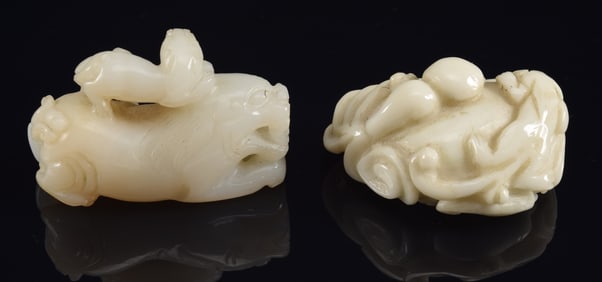 Two jade carvings. China. 20th century. Pair of foo dogs and a foo dog with a magic gourd. Each