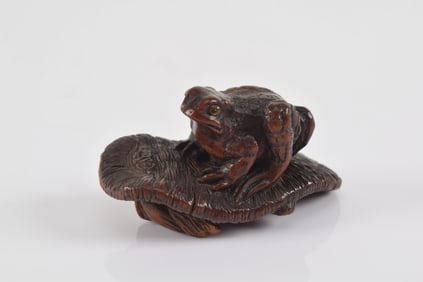 Carved wooden netsuke. Japan. 19th century. Kokei. Tsu-a toad on a waraji sandal. Inlaid eyes. 5 x 2