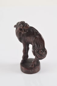 Carved wooden netsuke. Japan. 19th century. Masatoshi. Baying kirin on a base. 5 x 3cm.
