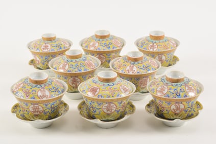 Porcelain covered teacups and saucers. Yellow ground decorated with auspicious symbols and clouds.