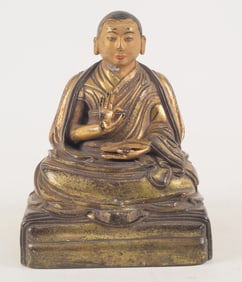 Gilt bronze image of a high lama. Tibet. 18th century. Seated figure holding an open sutra. 7in