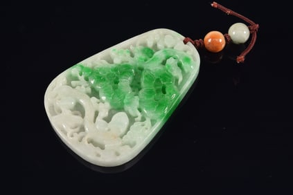 Jadeite pendant. China. 20th century. Oval shaped. Carved and pierced with dragons. 3in length.