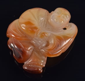 Agate carving of a child holding a lotus leaf. China. 19th century. 2.25in.