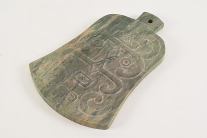 Carved hardstone axe. Surface with archaic motifs. Stone of a green and tan color. China. 20th