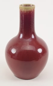 Sang de bouef vase. China. Early 20th century. Bottle form. Deep red glaze, celadon at the mouth.