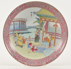 Porcelain plate. China. 20th century. Famille rose scene of the immortals. Magenta borders with