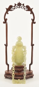 Carved bowenite jar and cover with hanging chains. Fitted stand. China. 20th century. Overall 16.5in