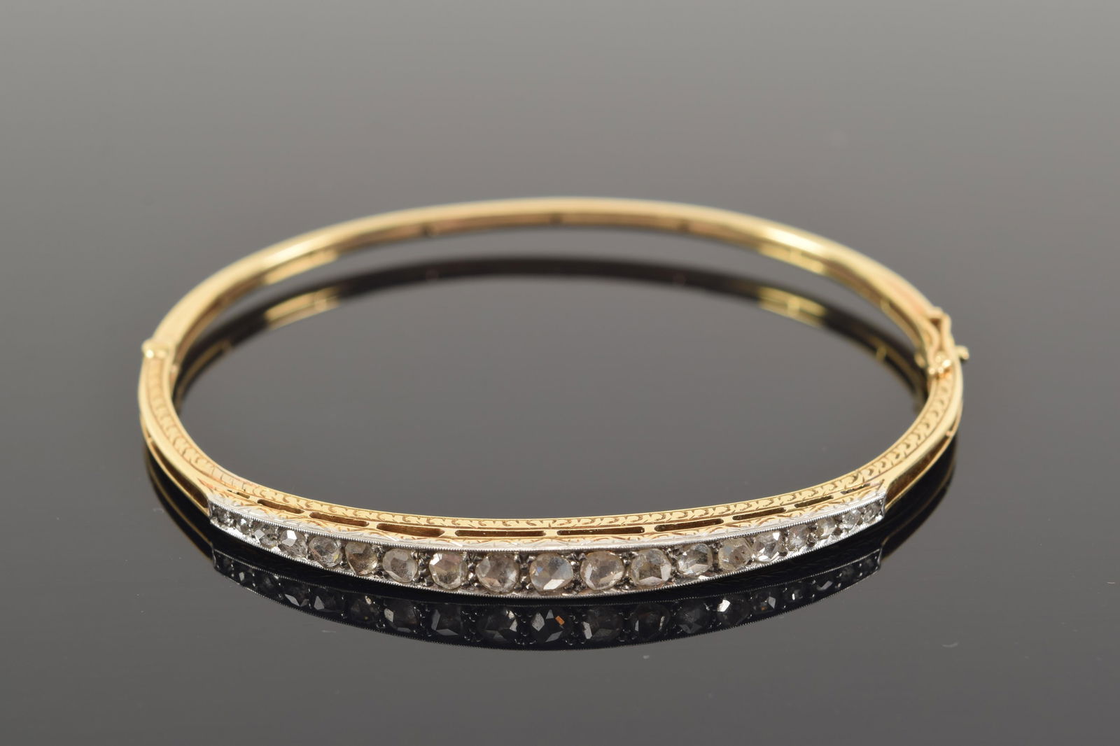 14K gold diamond mounted bangle bracelet. Set with 19 graduated mine cut diamonds, largest measuring (1 of 3)