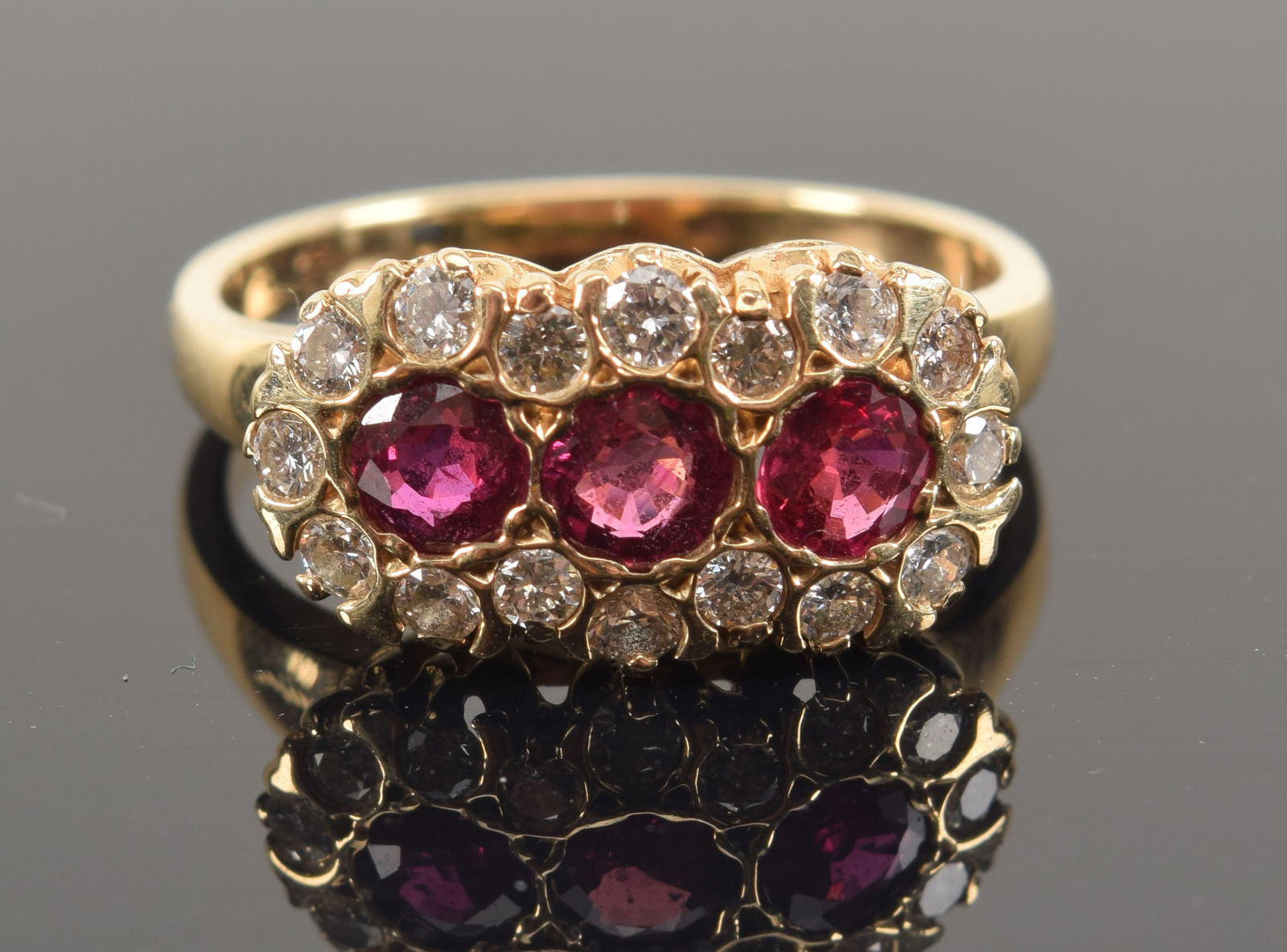 14K gold diamond and ruby mounted ring. 3 central round cut rubies measuring each approx. 3.5mm (1 of 5)