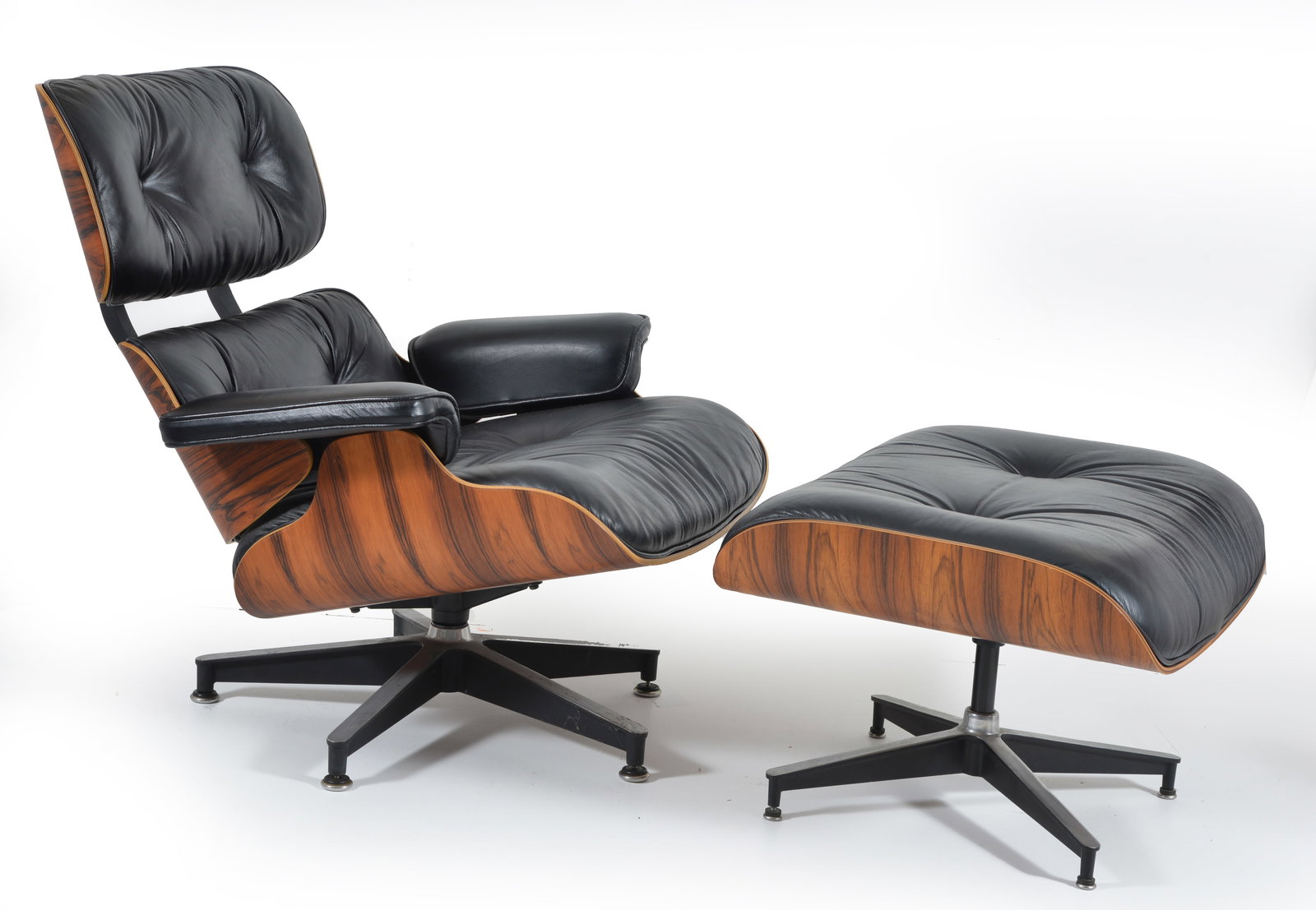 Charles and Ray Eames lounge chair and ottoman, late 20th Century. Rosewood laminate with black: Charles and Ray Eames lounge chair and ottoman, late 20th Century. Rosewood laminate with black leather upholstery. Good condition, very minor wear. Herman Miller label on both chair and ottoman. Chai