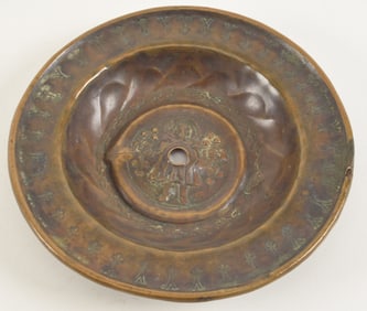 Renaissance brass alms dish with standing figure in the center with fleur de lis decoration. Later