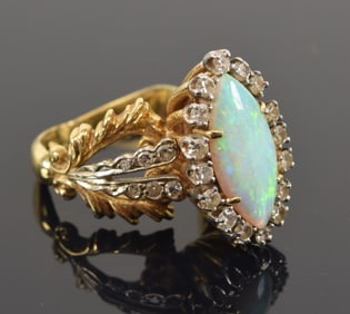 14K gold opal and diamond ring. Large marquis shaped opal measuring 7 x 14.5mm. Surrounded by halo