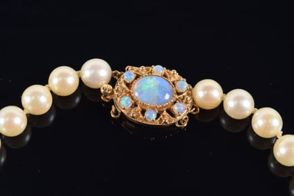 14K gold opal mounted pearl necklace. Clasp with large oval opal stone measuring 7.7 x 9.8mm and 6