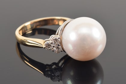 14K gold large pearl solitaire ring. Pearl measures approx. 13mm diameter. Flanked by 3 round cut