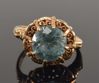 14K gold blue topaz mounted vintage ring. Round faceted stone measures 9mm diameter. Marked 14K and