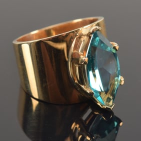 14K gold blue topaz mounted ring. Large topaz measuring about 9 x 17.5mm. Marked 14KT G. Ring size