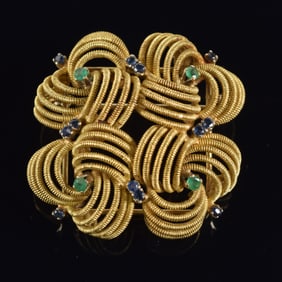 18K gold interwoven openwork pin set with small round sapphires and emeralds. Hallmarked on reverse.