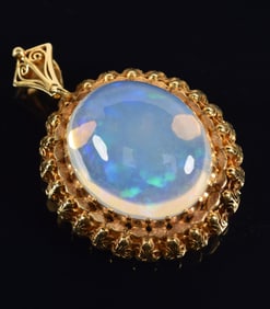 18K gold opalite mounted pendant. Ornate openwork gold setting. Opalite measures approx. 21 x 25mm.