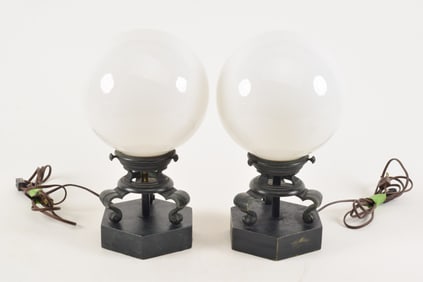 Pair of bronze mounted table lamps with white glass globe shades. Bronze bases with fine dark green