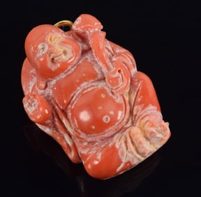 Carved coral buddha pendant. 1.25in length.