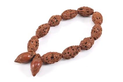 Antique Chinese carved peach pit bead bracelet with pierced figural and architectural decoration.