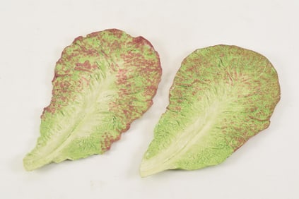 Mary Kirk Kelly tromp l'oeil lettuce form ceramic plates. Signed on underside. 9.75in length.